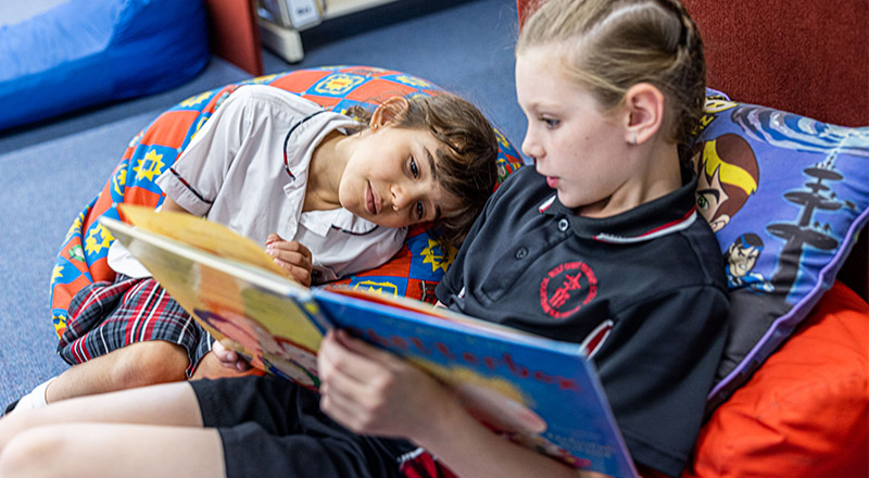 Girls reading in the Holy Spirit Catholic Primary St Clair school library