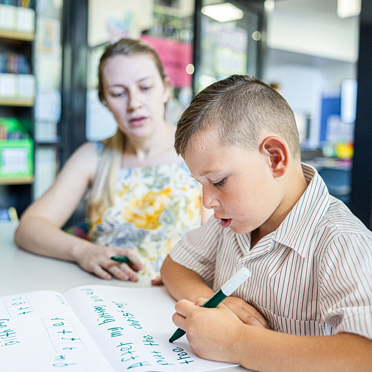 Teacher helping student Holy Spirit Primary St Clair